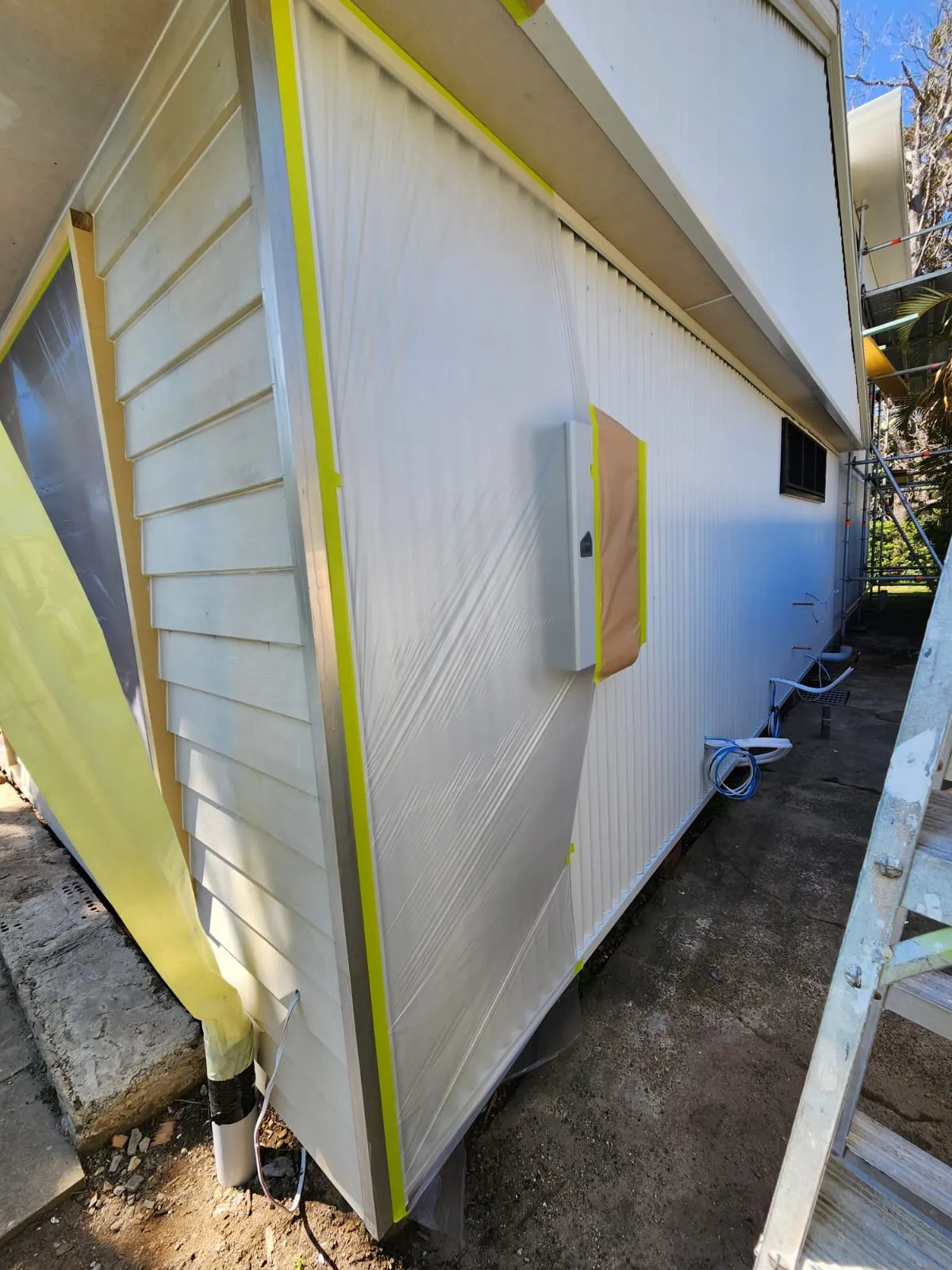Exterior weatherboard wrapped and masked at the start of a coastal Newcastle repaint