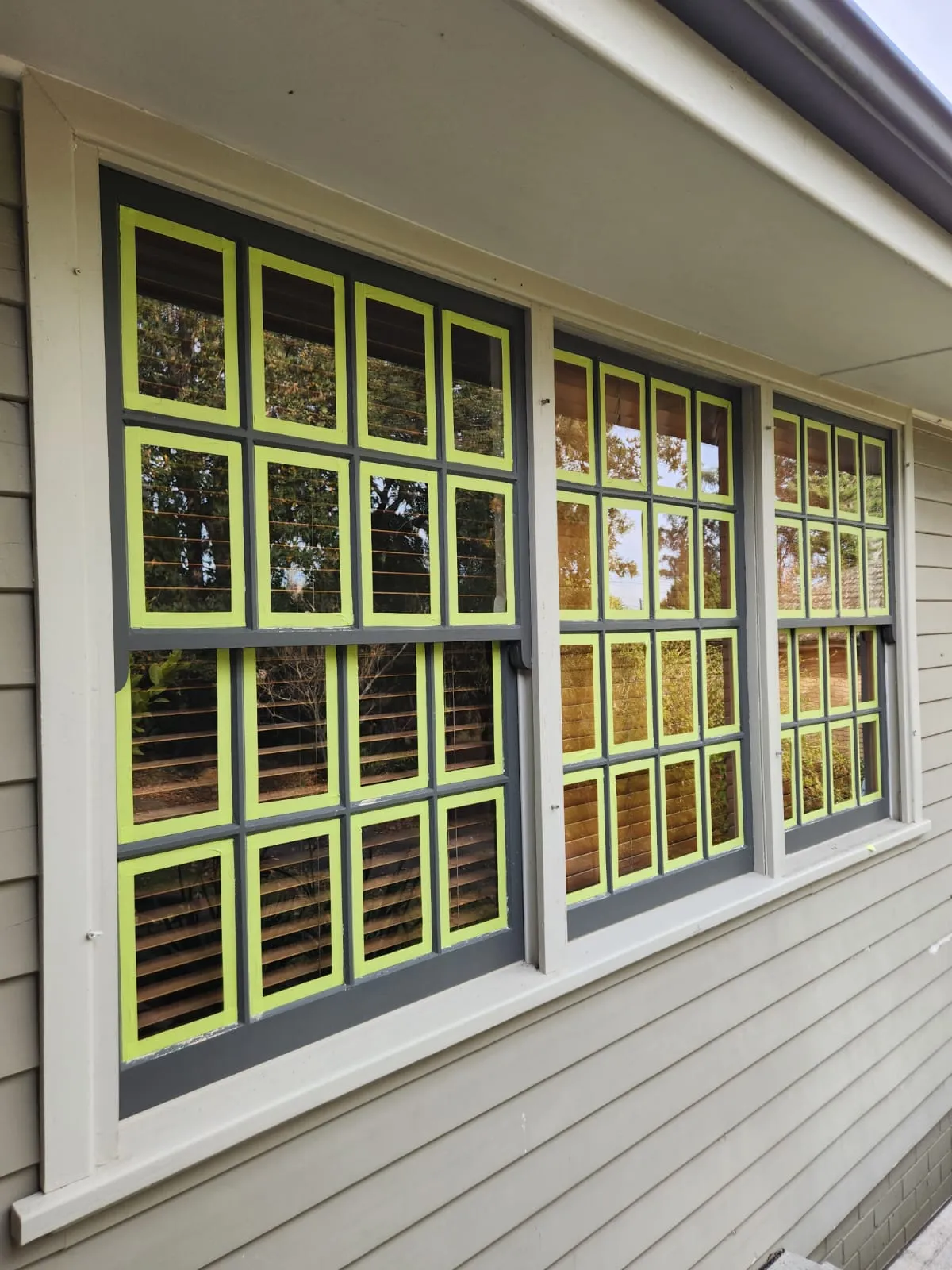 Exterior windows masked with tape and grey frames during painting