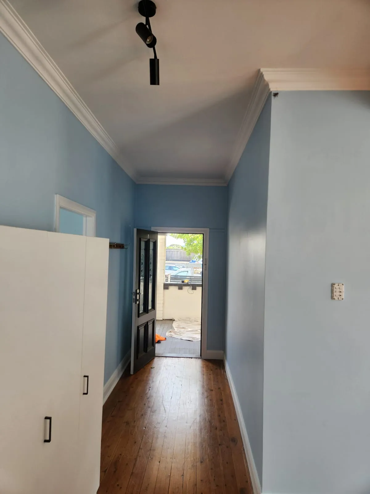 Hallway in a Newcastle home repainted in blue with white trim