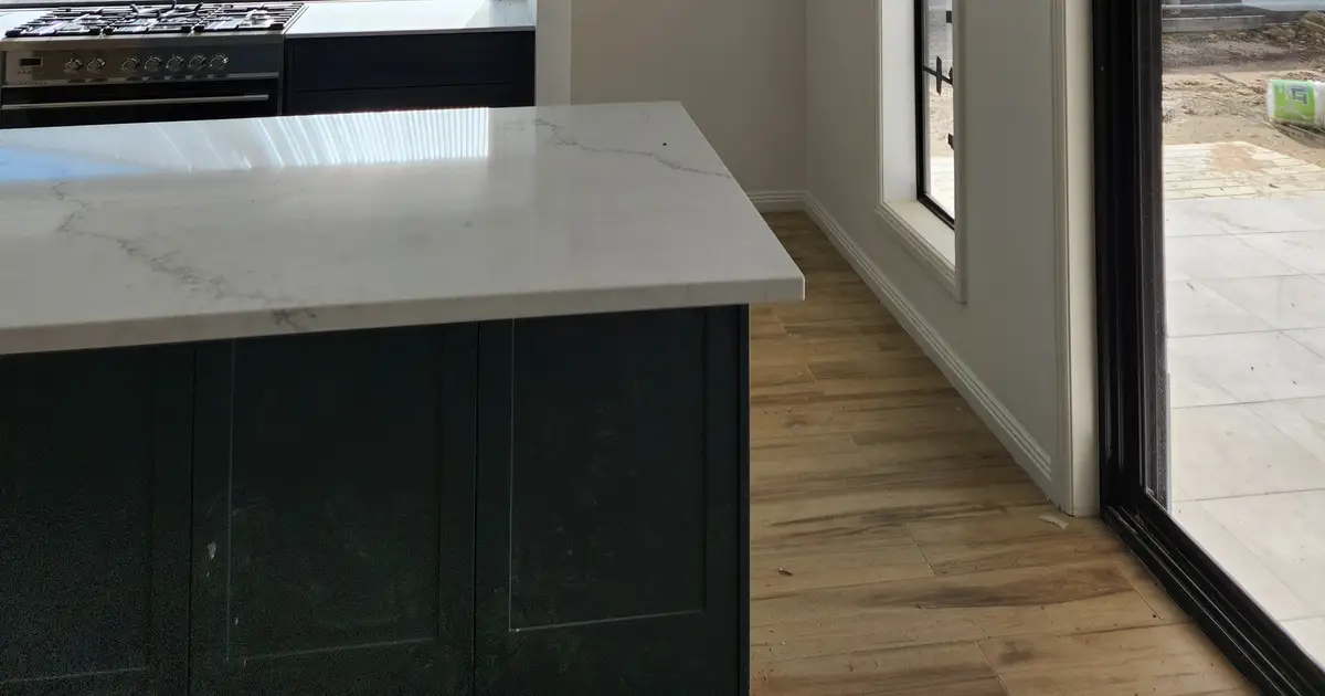 White kitchen cabinetry and stone island in a Newcastle home after painting