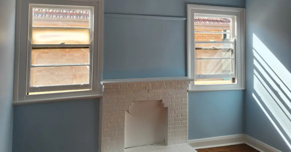 Repainted bedroom with timber sash windows, a picture rail and a white brick fireplace