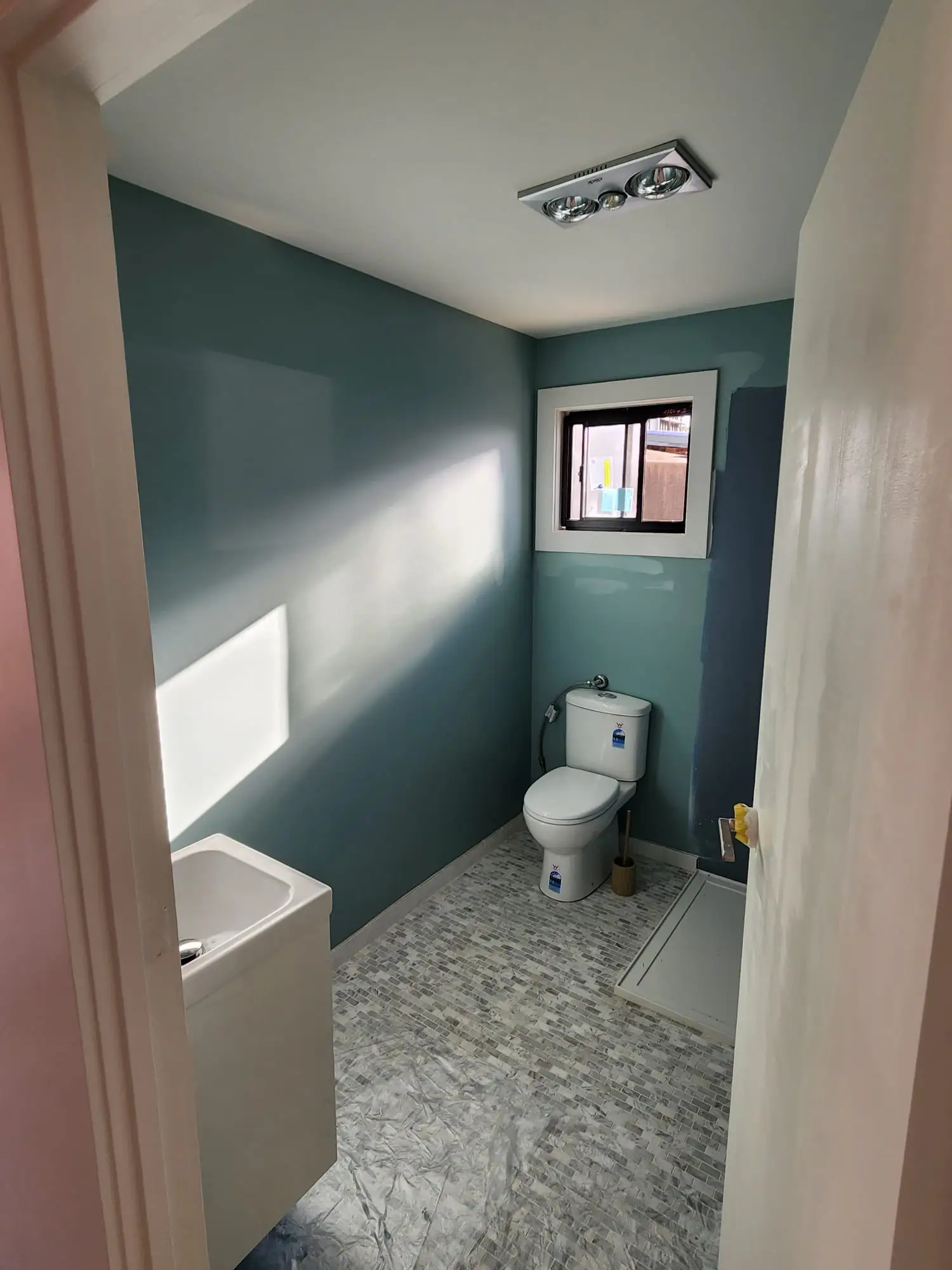 Teal bathroom feature wall with painted trim
