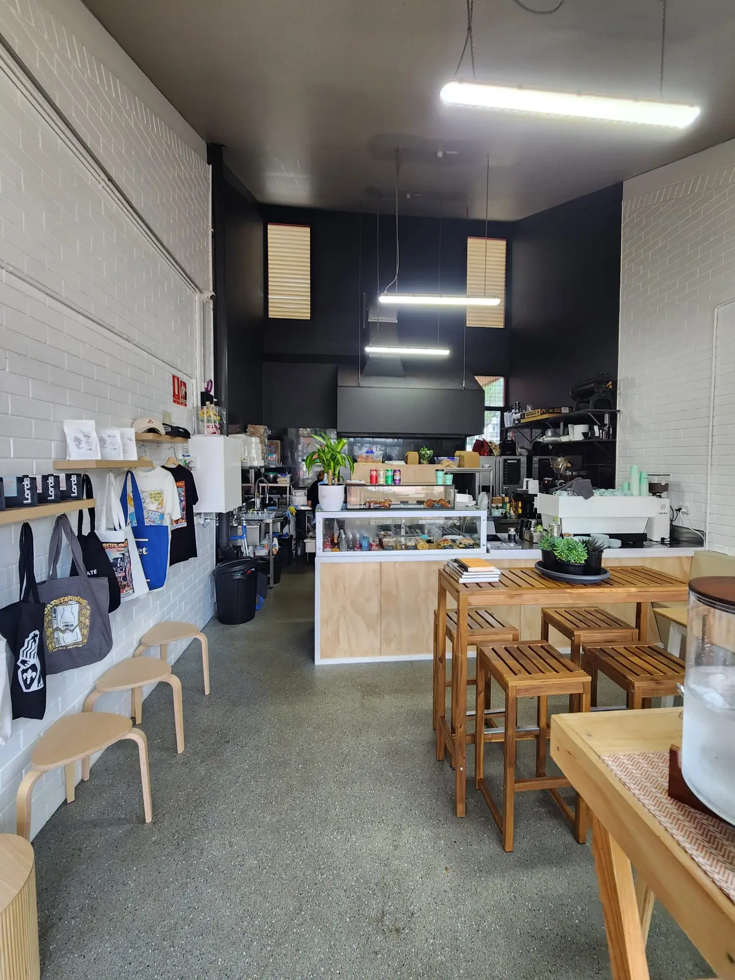 Cafe interior with white painted brick walls and a black feature ceiling