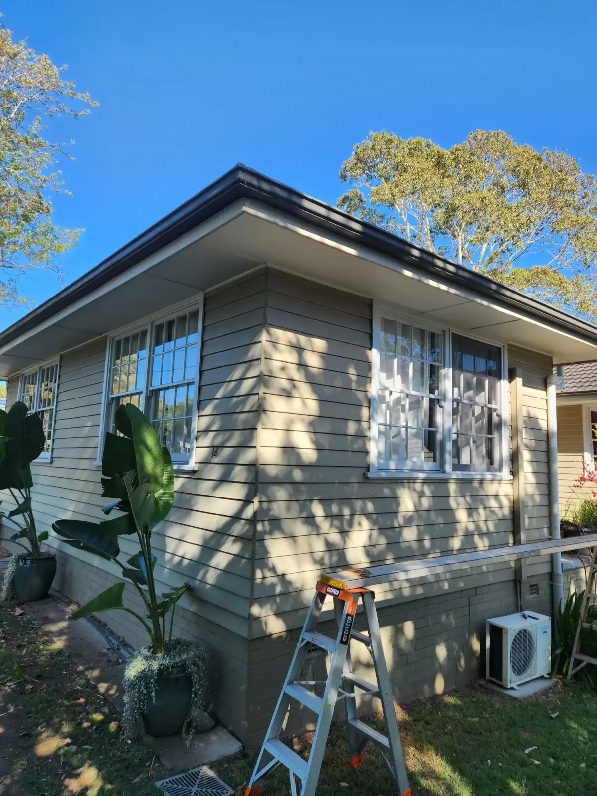Repainted exterior of a Newcastle home with a coated brick base course