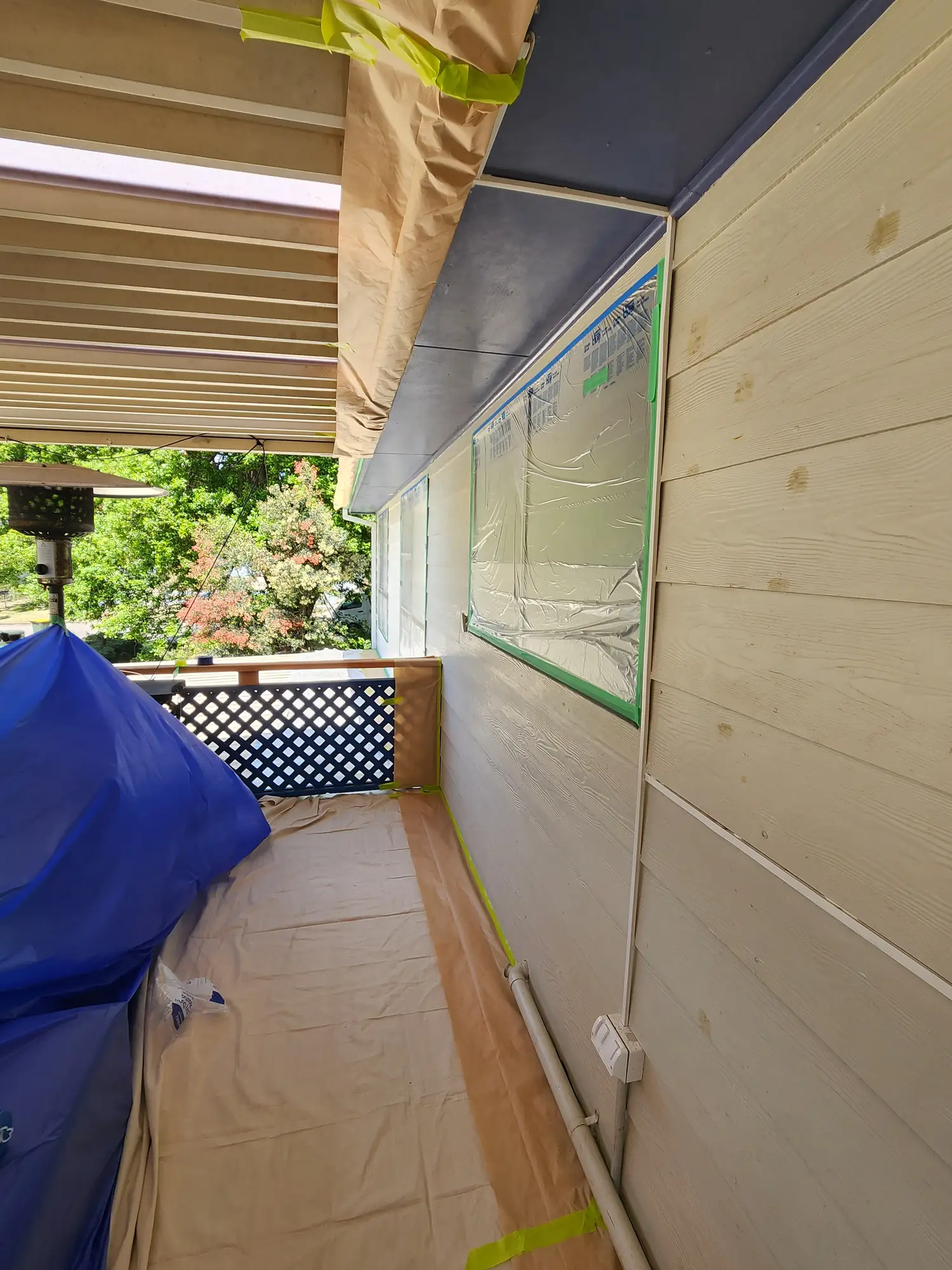 Exterior window frames masked with tape during painting preparation
