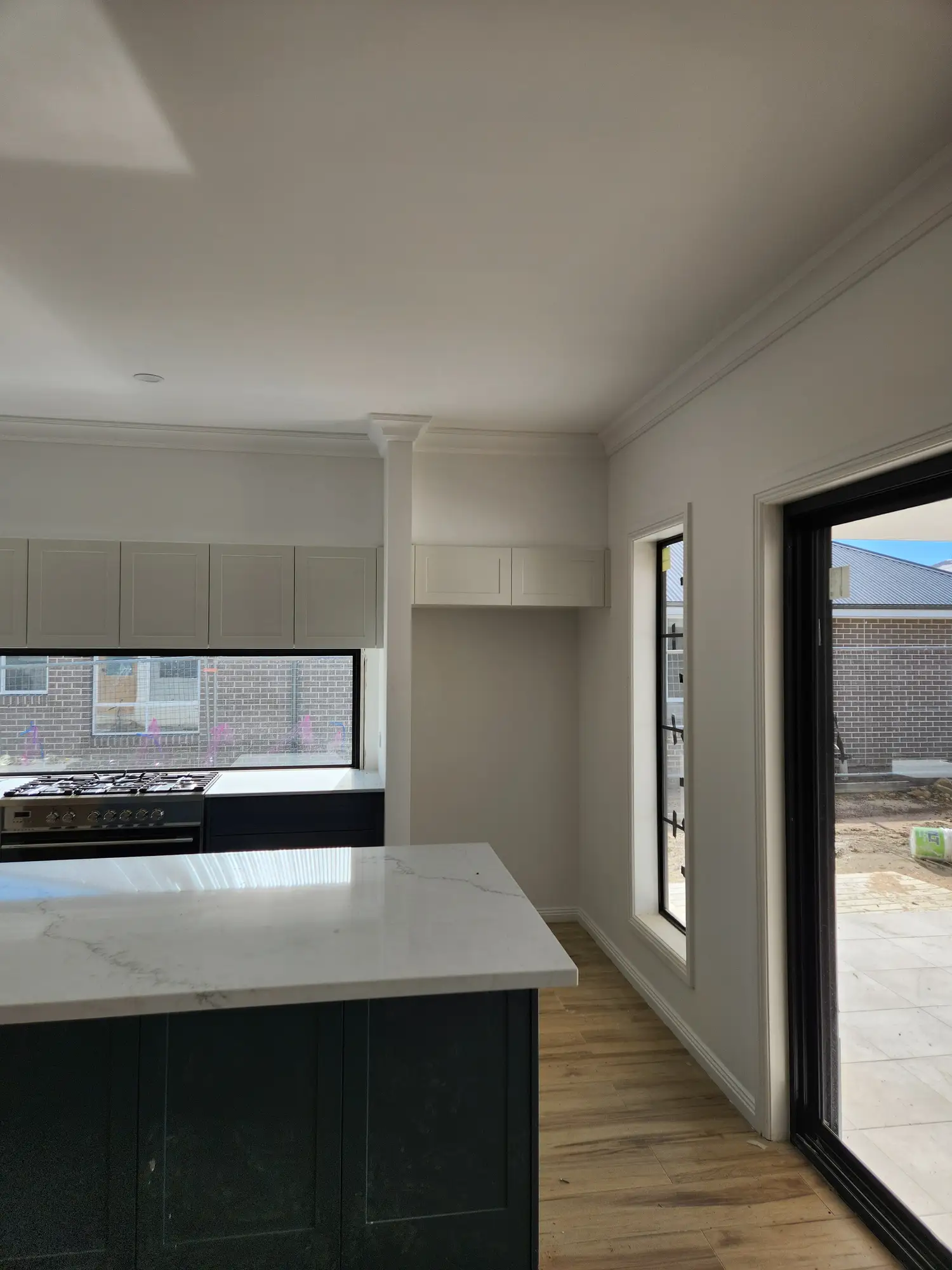 White kitchen cabinetry and stone island after painting